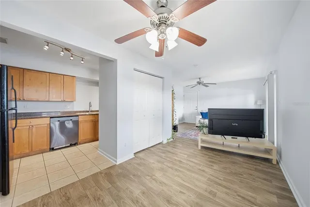 a view of a kitchen with a sink and dishwasher a stove top oven with a bookshelf