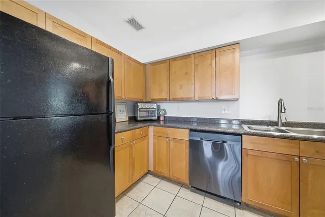 a kitchen with stainless steel appliances granite countertop a sink and a refrigerator