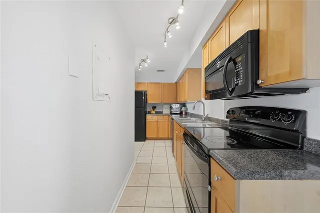 a kitchen with stainless steel appliances granite countertop a sink and a stove