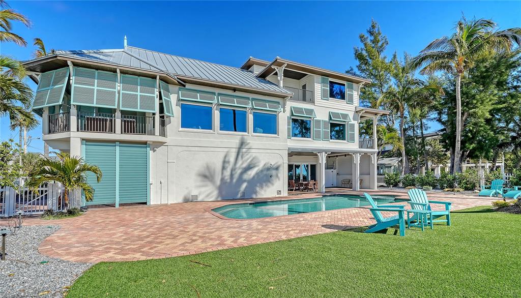 95 52nd Street Holmes Beach, FL 34217 - Photo 64 of 73 a front view of a house with a yard table and chairs