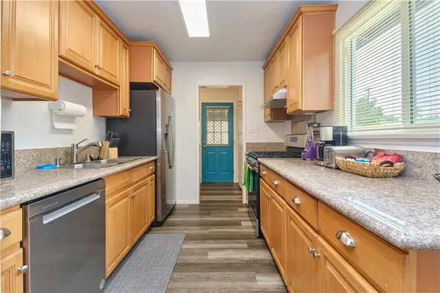 a kitchen with stainless steel appliances granite countertop a sink and a stove