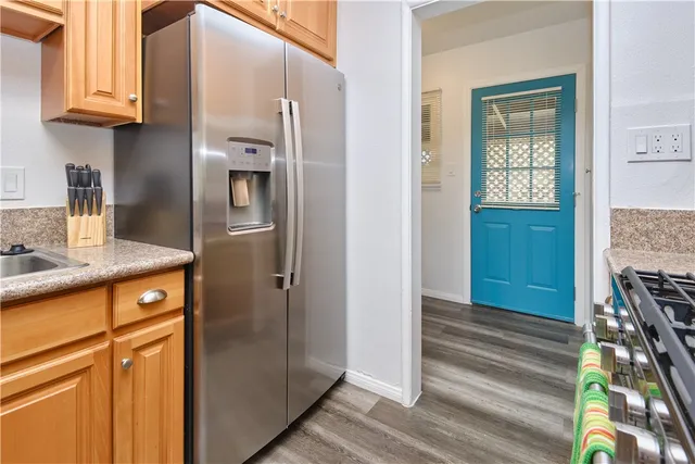 a kitchen with stainless steel appliances granite countertop a refrigerator and a sink
