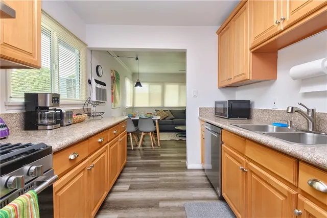 a kitchen with stainless steel appliances granite countertop sink stove top oven and cabinets
