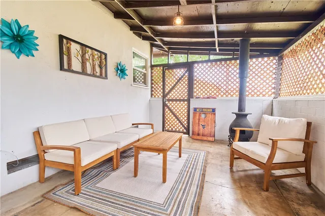 a backyard of a house with table and chairs plants and large tree