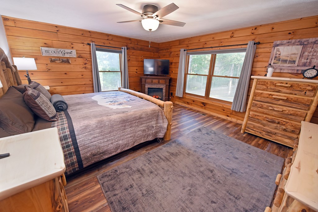 90 Log Cabin Road Blairsville, GA 30512 - Photo 23 of 45 a bedroom with a large bed and a flat tv screen