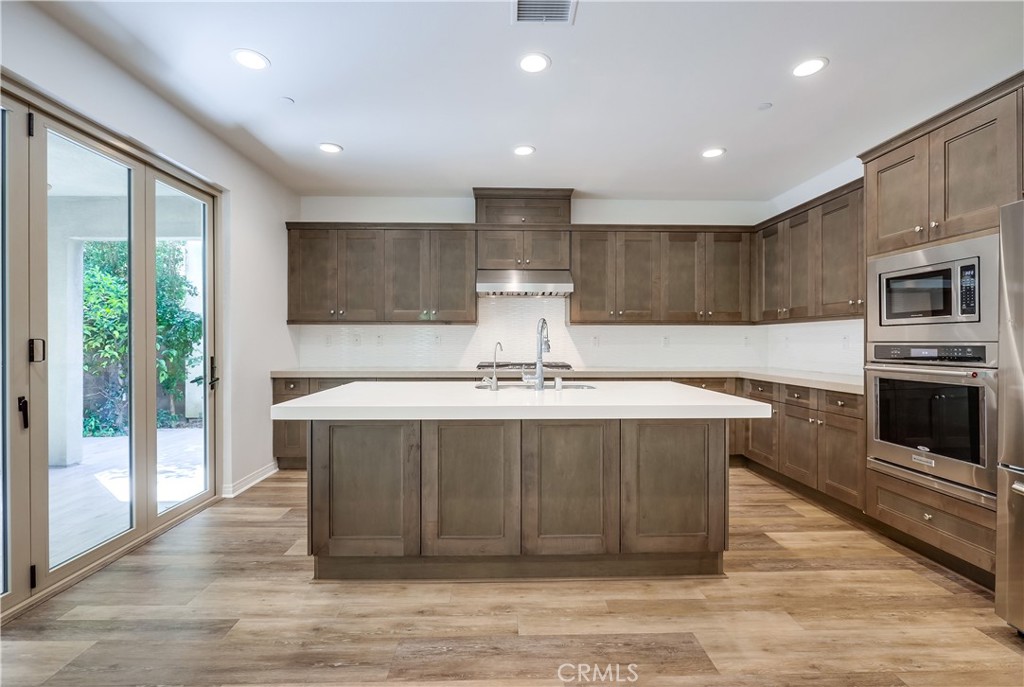 138 Brambles Irvine, CA 92618 - Photo 6 of 39 a kitchen with a stove a sink and a refrigerator