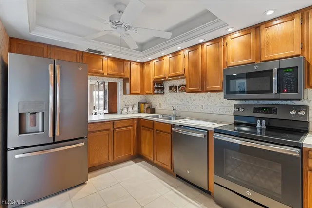 a kitchen with stainless steel appliances granite countertop a refrigerator a stove top oven a sink dishwasher a dining table and chairs with wooden floor