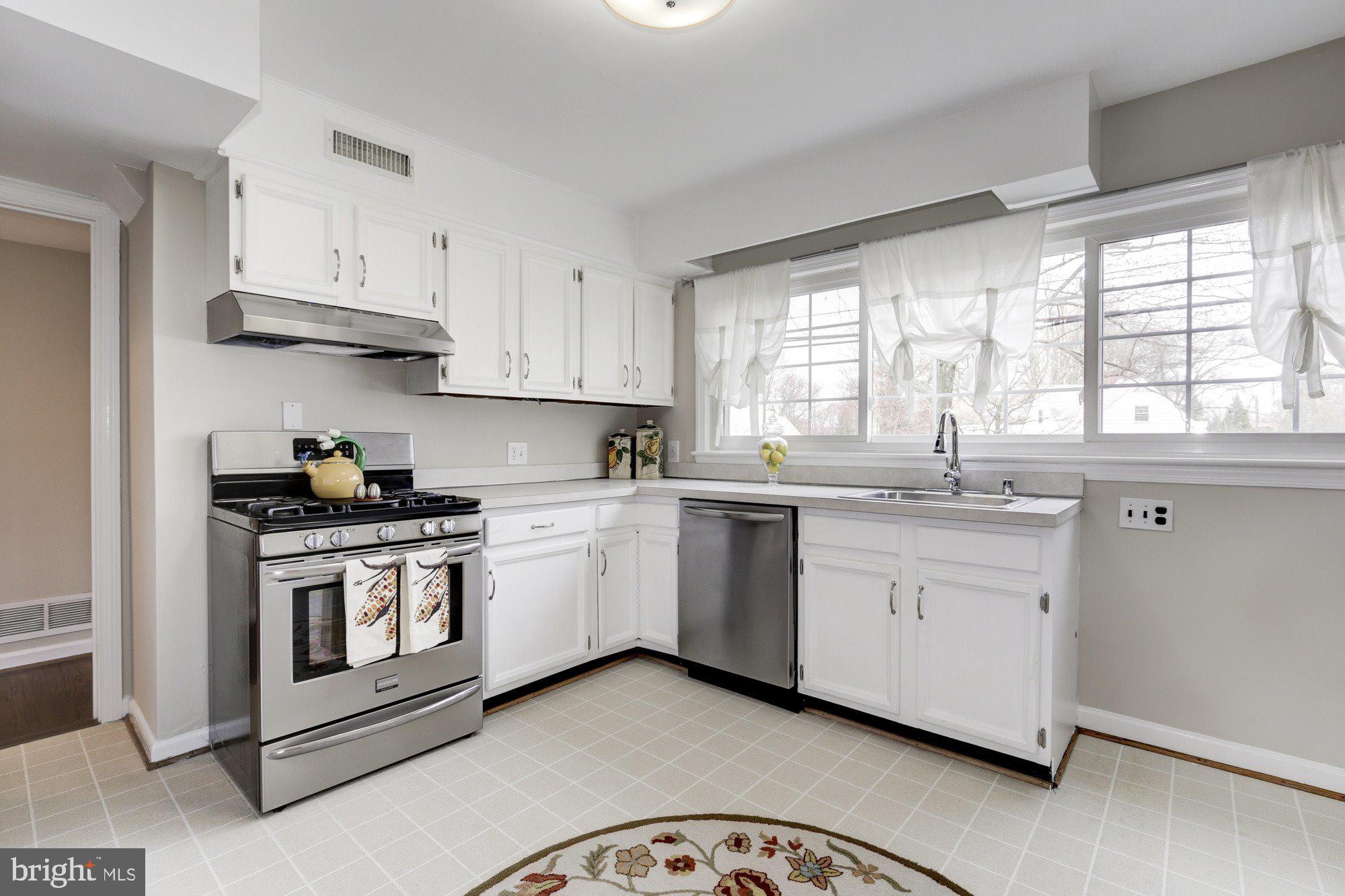 2802 Dawson Avenue Silver Spring, MD 20902 - Photo 5 of 30 a kitchen with granite countertop white cabinets and white stainless steel appliances