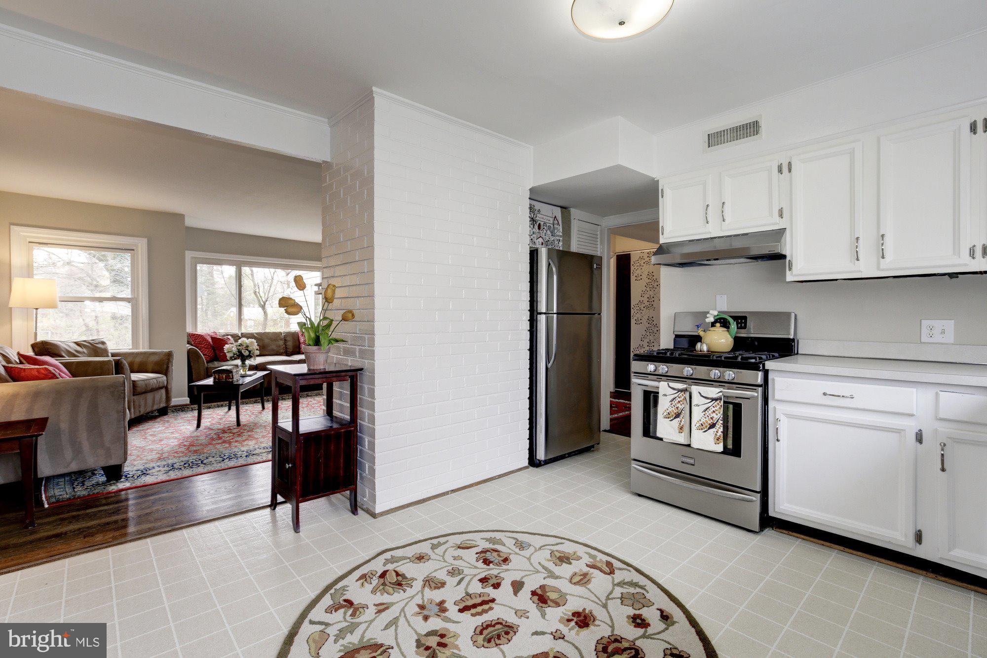 2802 Dawson Avenue Silver Spring, MD 20902 - Photo 6 of 30 a kitchen with stainless steel appliances granite countertop a stove a sink a refrigerator and white cabinets with wooden floor