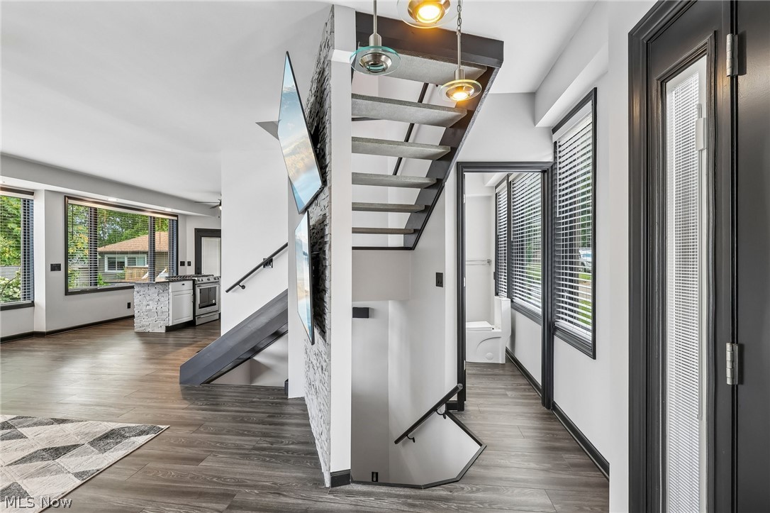 5490 Springlake Road Northwest Canton, OH 44718 - Photo 14 of 50 Modern open-tread staircase with integrated pendant lighting, contrasting with a textured accent wall