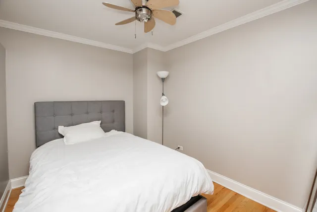a bedroom with a bed and a chandelier fan