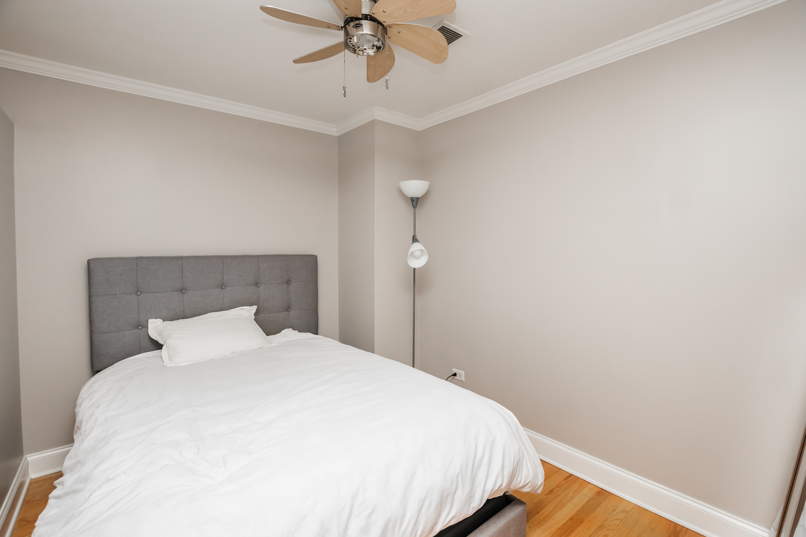 4144 North Sheridan Road, Unit 409 Chicago, IL 60613 - Photo 14 of 17 a bedroom with a bed and a chandelier fan