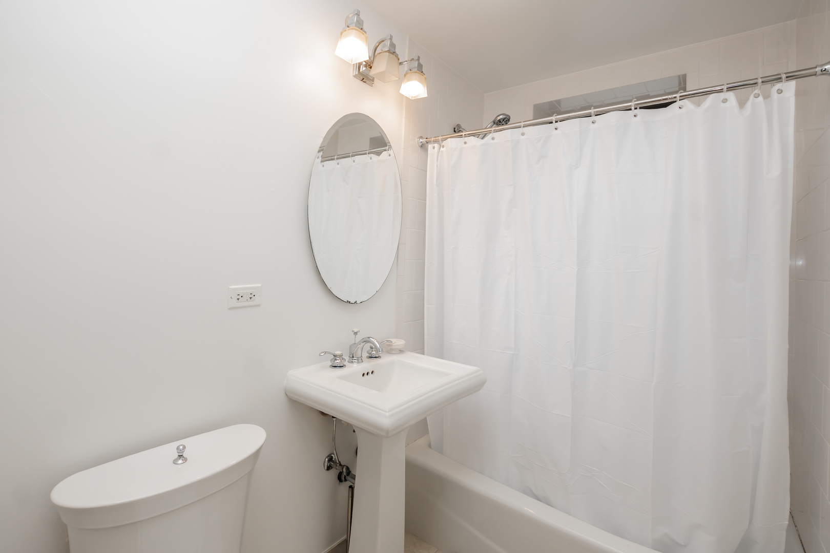 4144 North Sheridan Road, Unit 409 Chicago, IL 60613 - Photo 15 of 17 a bathroom with a sink a toilet and shower curtain