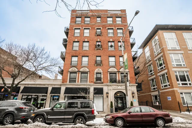 a front view of a building with lot of cars parked