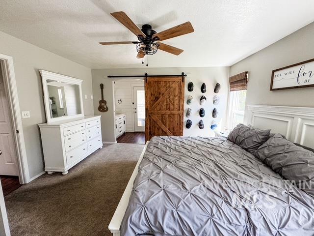 808 O'Leary Way Twin Falls, ID 83301 - Photo 20 of 37 Spacious bedroom featuring plush carpeting, a ceiling fan with wood-finish blades, and a prominent wood barn door