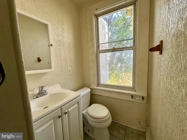 a bathroom with a sink toilet and a mirror
