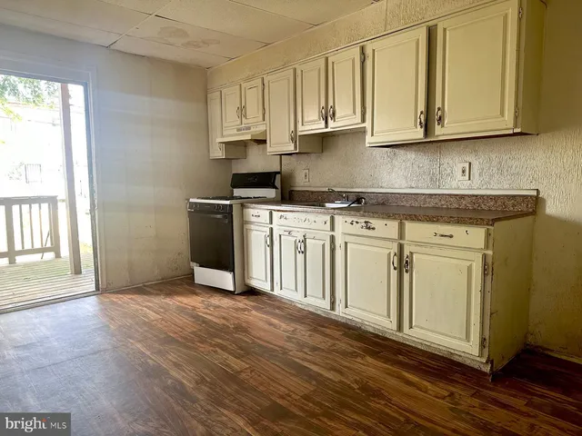 a kitchen with stainless steel appliances granite countertop a stove a sink and white cabinets