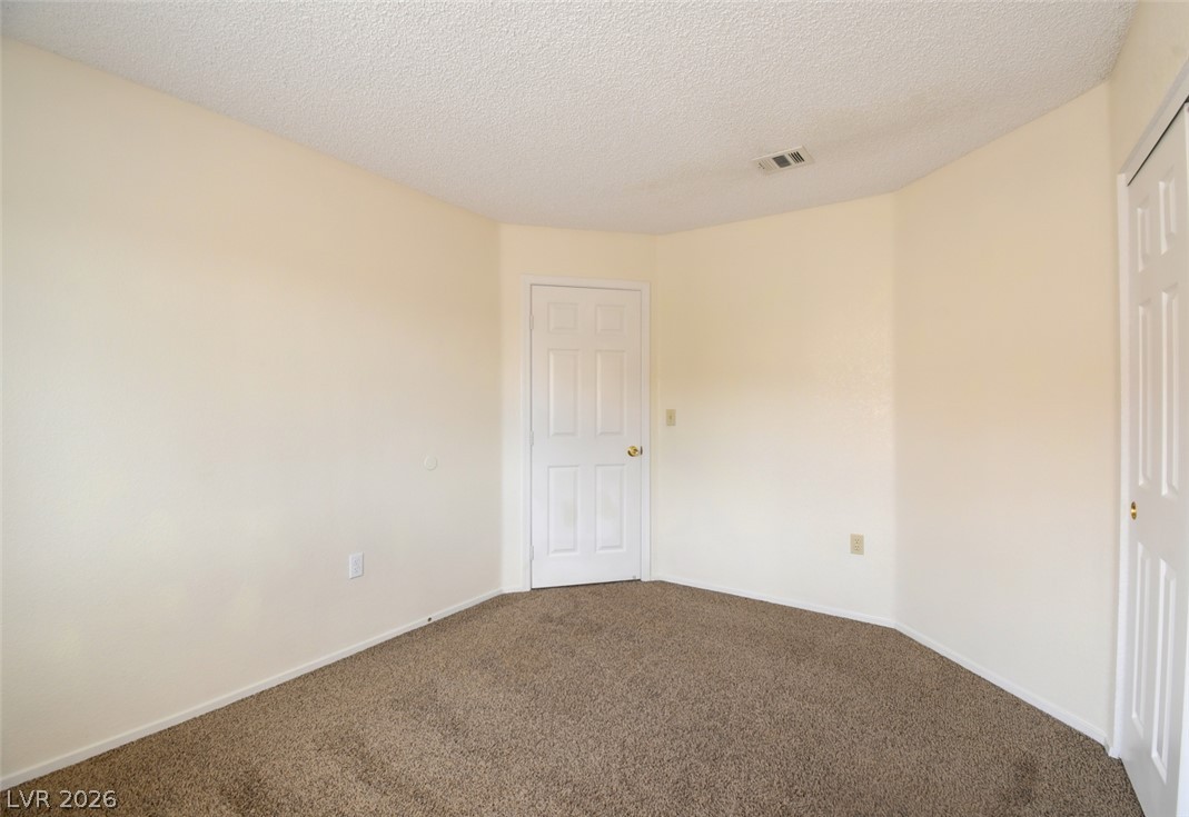 5 Tarryall Terrace Henderson, NV 89074 - Photo 29 of 44 A spacious, naturally illuminated room features plush carpeting and a neutral palette, offering a blank canvas for personalization.