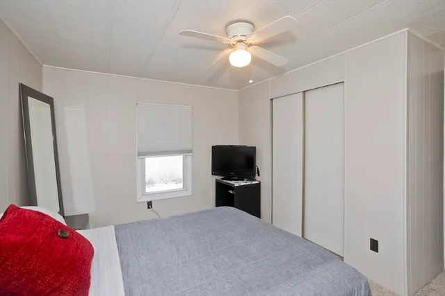 a bedroom with a bed and a flat tv screen on dresser