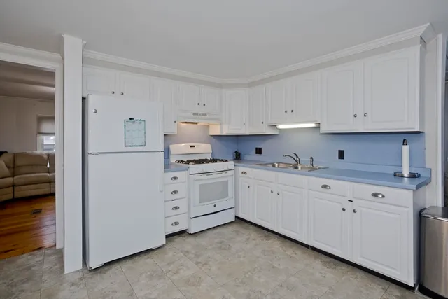 a kitchen with granite countertop white cabinets and white appliances