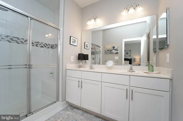 a bathroom with a shower sink and mirror