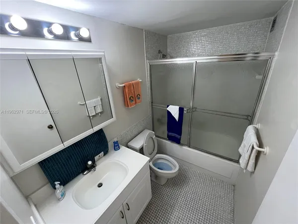 a bathroom with a sink vanity mirror and toilet