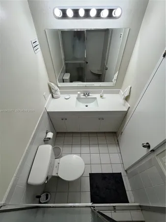 a bathroom with a sink a toilet and mirror