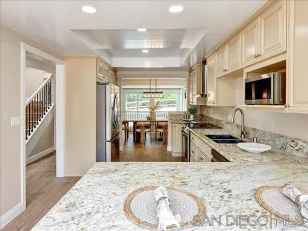a kitchen with stainless steel appliances granite countertop a sink stove and refrigerator