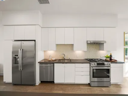 a kitchen with granite countertop a stainless steel appliances cabinets and a counter top space