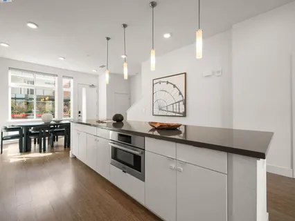 a kitchen with stainless steel appliances granite countertop a stove a sink and a wooden floor