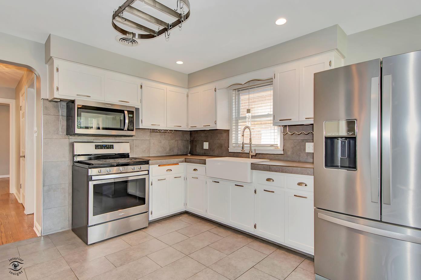 10348 South Rhodes Avenue Chicago, IL 60628 - Photo 11 of 20 a kitchen with stainless steel appliances granite countertop a refrigerator a stove a sink and a microwave