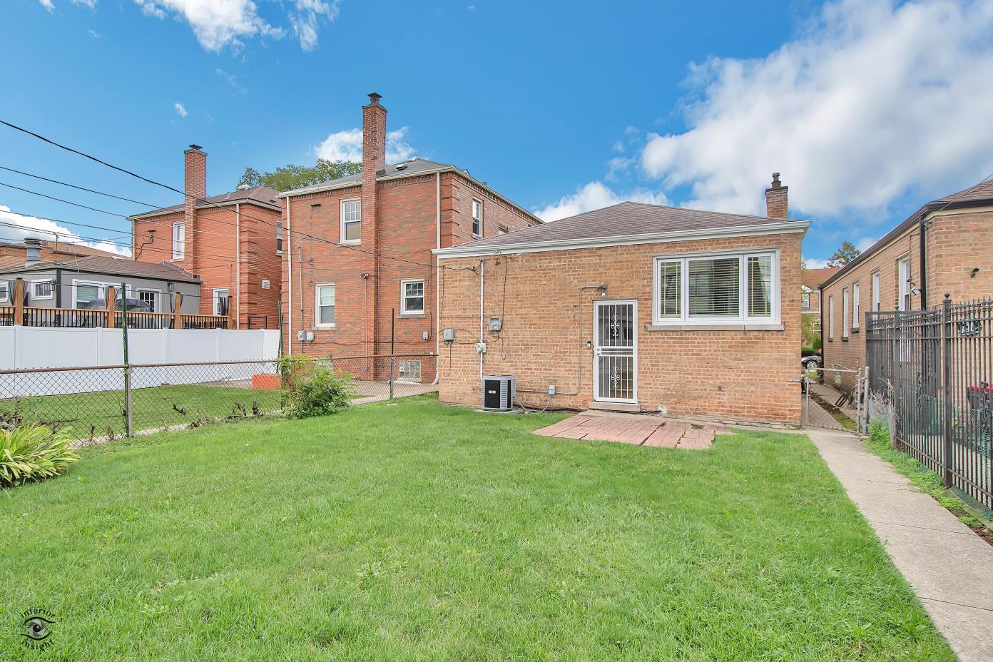 10348 South Rhodes Avenue Chicago, IL 60628 - Photo 15 of 20 a front view of a house with a yard