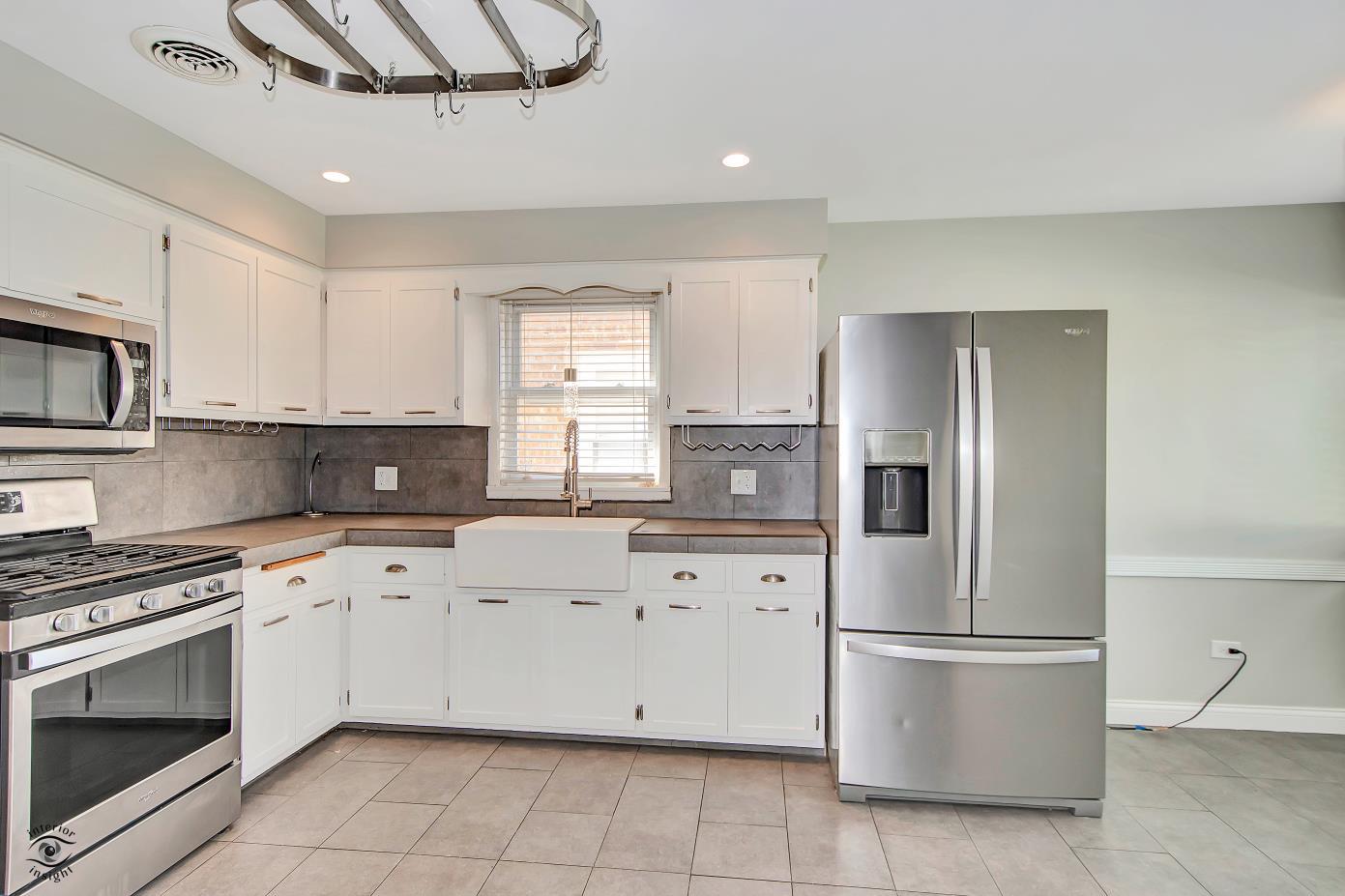 10348 South Rhodes Avenue Chicago, IL 60628 - Photo 10 of 20 a kitchen with cabinets stainless steel appliances and window