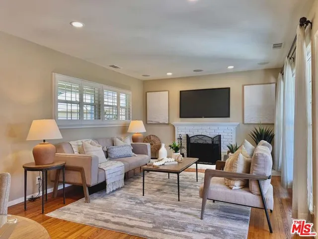 a living room with furniture a fireplace and a flat screen tv