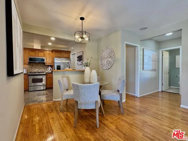 a view of a dining room with furniture a chandelier and wooden floor