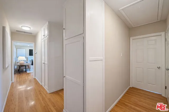 a view of a hallway with wooden floor and a bedroom