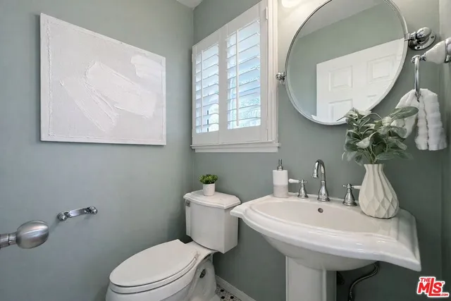 a bathroom with a toilet sink and mirror