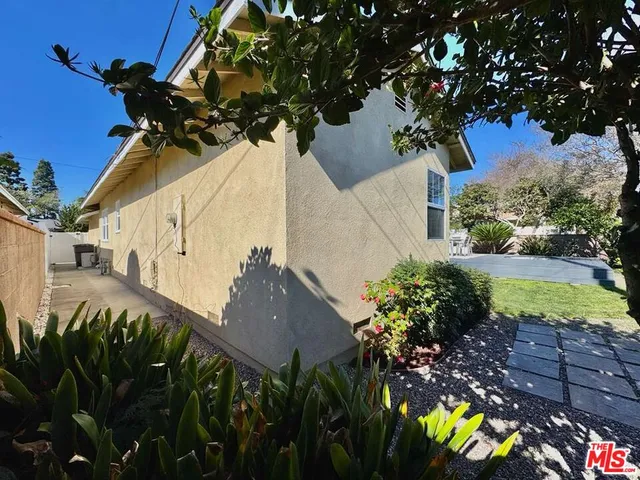 a view of a house with a yard and potted plants
