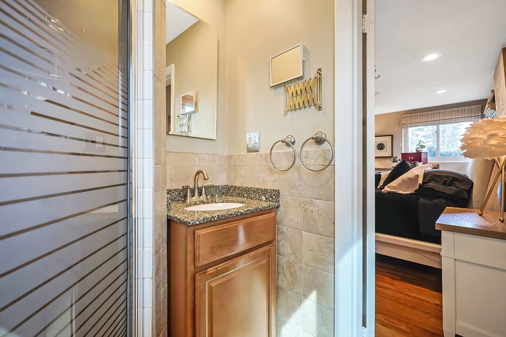 33 Debra Lane Framingham, MA 01701 - Photo 18 of 40 a bathroom with a granite countertop sink a mirror and shower