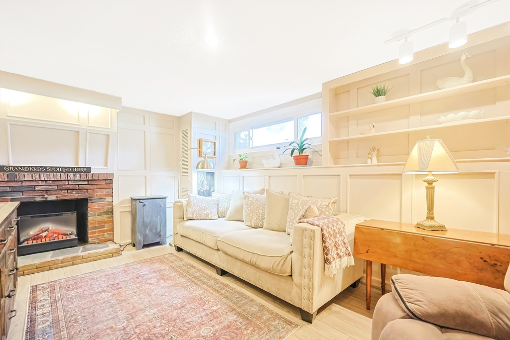 33 Debra Lane Framingham, MA 01701 - Photo 24 of 40 a living room with furniture a fireplace and a table