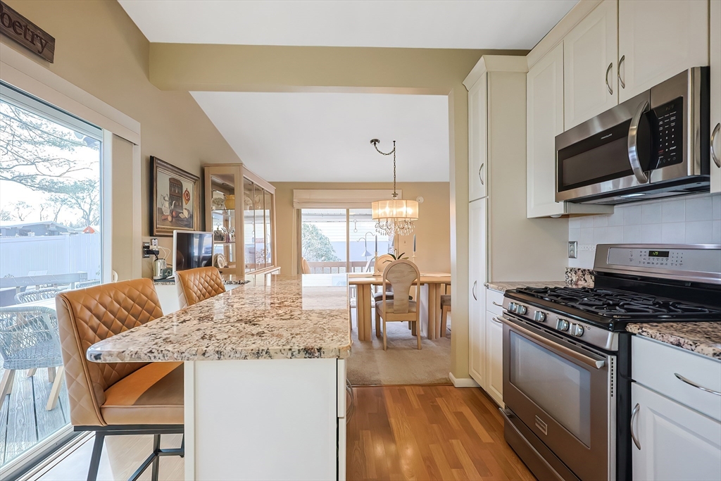33 Debra Lane Framingham, MA 01701 - Photo 10 of 40 a kitchen with stainless steel appliances kitchen island granite countertop a stove a sink and a microwave
