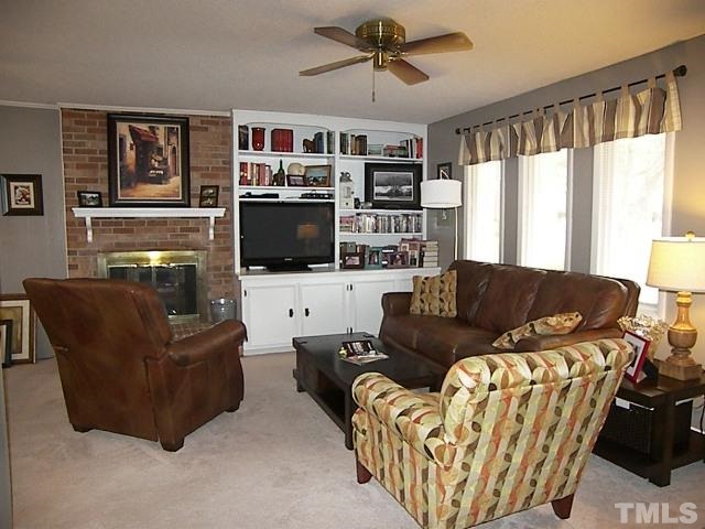 1502 Kennon Road Garner, NC 27529 - Photo 2 of 25 Relax in your spacious living room complete with lovely built in bookcases and cabinetry, as well a a cozy gas fireplace.