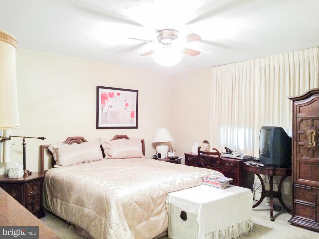 7512 Labyrinth Road Pikesville, MD 21208 - Photo 13 of 24 a bedroom with a bed and a flat screen tv