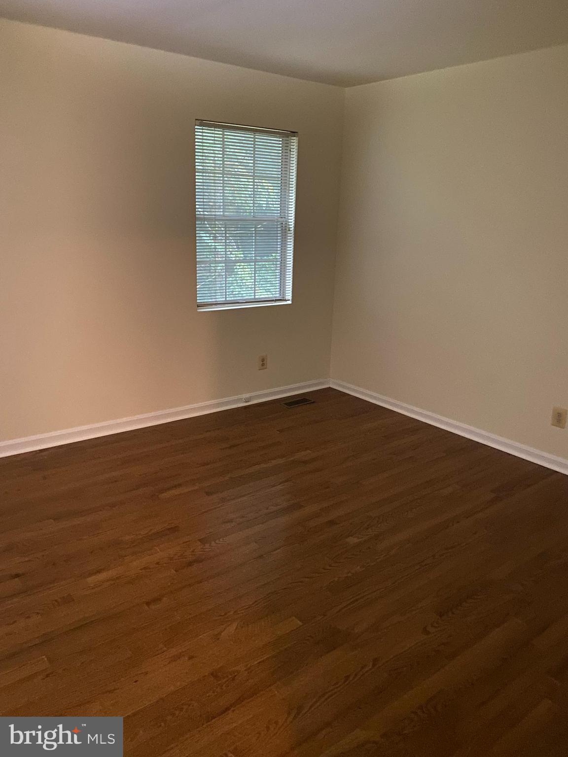 9006 Pickwick Village Terrace Silver Spring, MD 20901 - Photo 12 of 13 an empty room with wooden floor and windows
