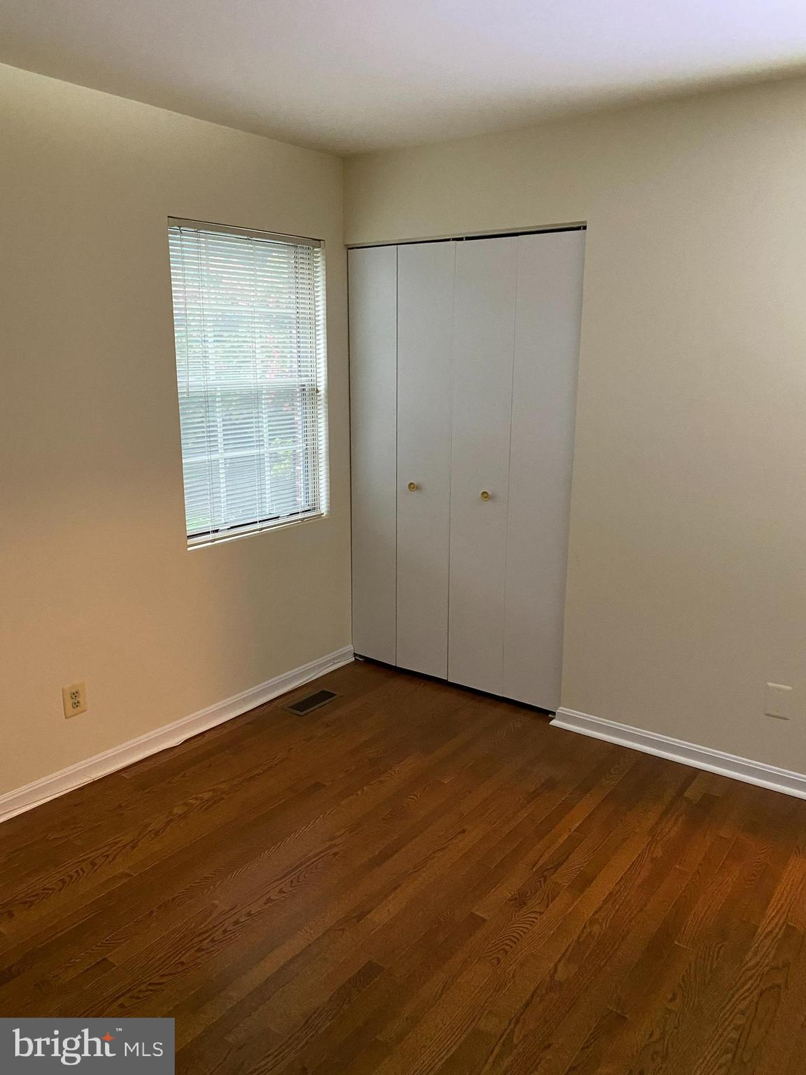 9006 Pickwick Village Terrace Silver Spring, MD 20901 - Photo 9 of 13 an empty room with wooden floor and windows