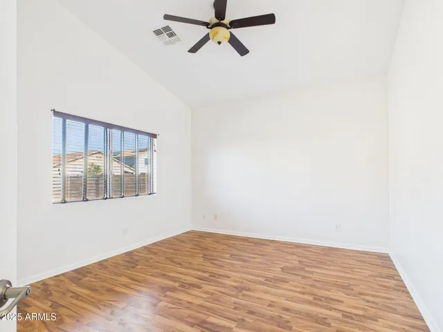 a view of a big room with wooden floor and windows