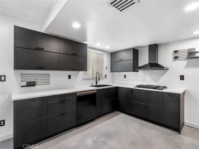 a large kitchen with stainless steel appliances a sink and cabinets