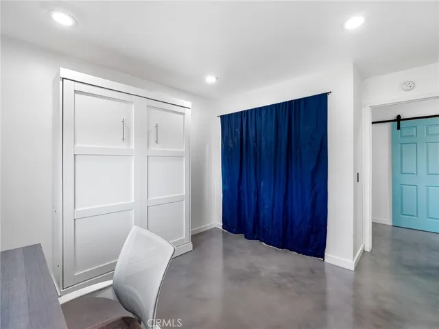 a view of an empty room with wooden floor and closet