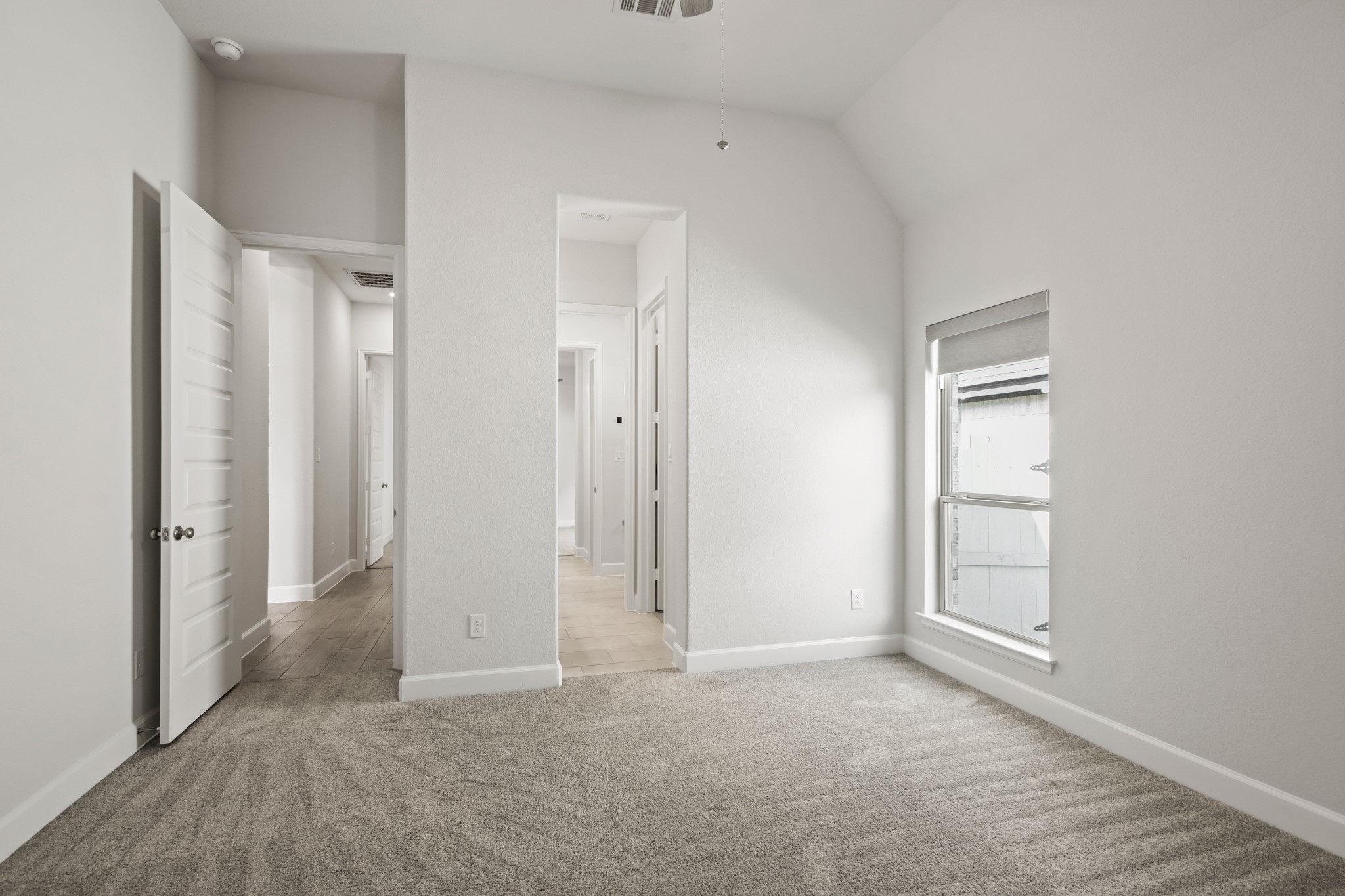 17406 Bayflower Conroe, TX 77385 - Photo 26 of 35 Bright, carpeted secondary bedroom with neutral walls, featuring a high ceiling and a large window for natural light.