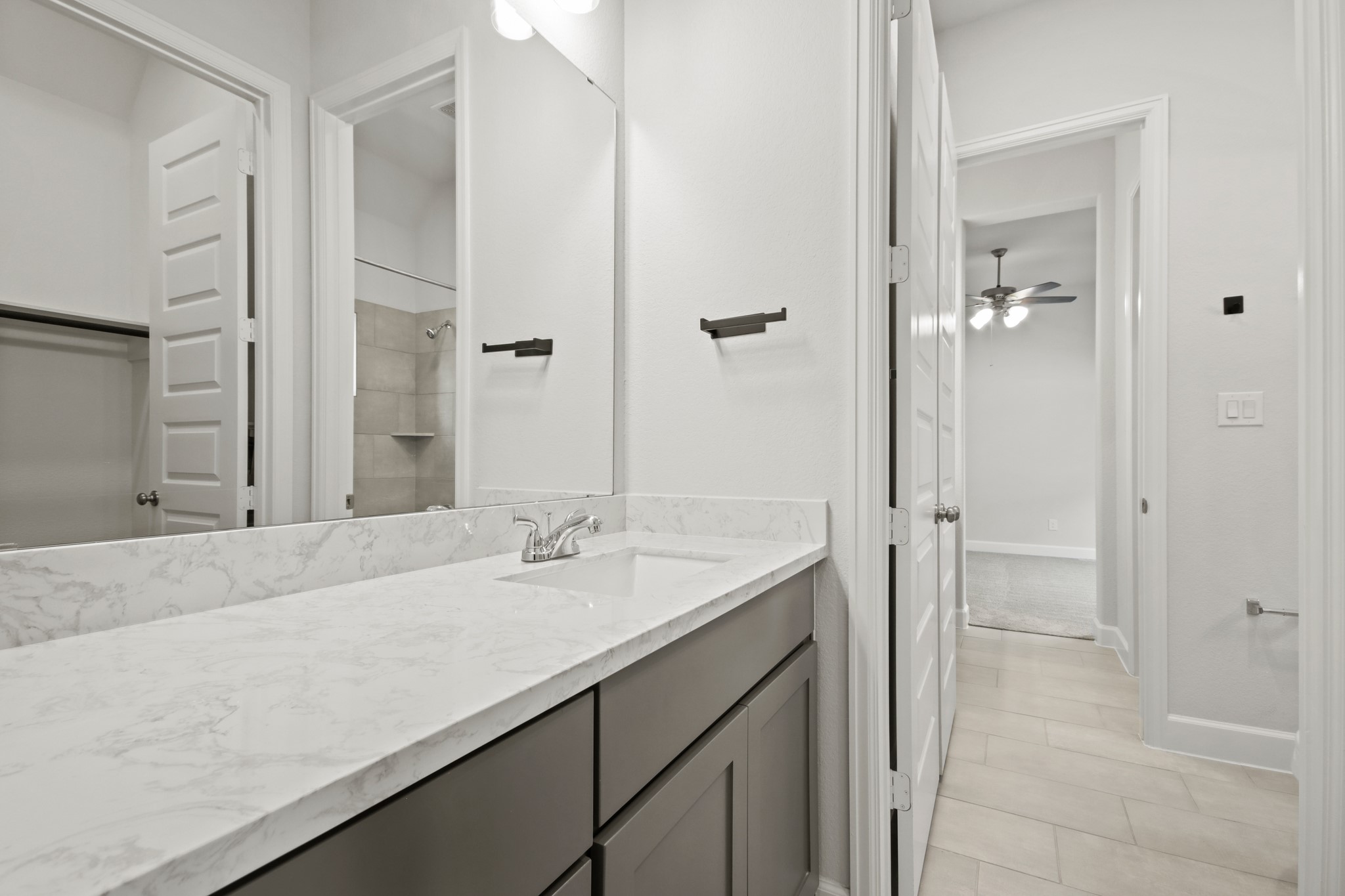 17406 Bayflower Conroe, TX 77385 - Photo 28 of 35 Modern bathroom with a sleek marble countertop and built-in sink. This like new space is bright, with modern fixtures.